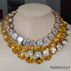 Naszyjniki z wyrazistymi zdobieniami Anny Wintour, naszyjnik z owalnym topazem z kryształu austriackiego, naszyjnik z kwadratowymi diamentami Imperial, naszyjnik z kwadratowym, różowym szlifem Old Mine