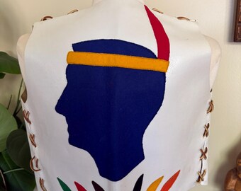 May include: White leather vest featuring a blue silhouette with a yellow headband and red feather. The vest has brown lacing on the sides and colorful accents at the bottom. The vest is displayed on a mannequin.
