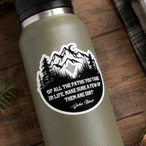 Adesivo con citazione di John Muir e montagna, ideale per gli amanti della natura e dell'escursionismo, perfetto per chi ama viaggiare all'aria aperta.