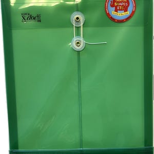 May include: A translucent green plastic document folder featuring a string and button closure mechanism. The front displays the black text Xerox xdocit and a circular red sticker with the text Creative Shapes Etc. Made in the USA.