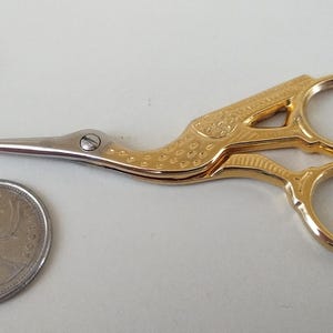 Tijeras pequeñas de bordar italianas vintage con diseño de cigüeña en tonos dorados y plateados, como nuevas + estuche