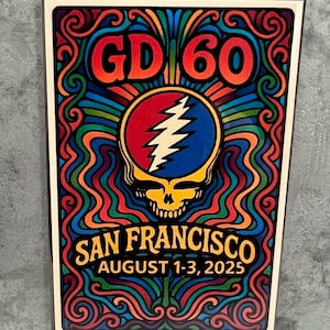 May include: A colorful poster with the text "GD 60" in orange, and "SAN FRANCISCO AUGUST 1-3, 2025" in gold. The central image is a red, blue, and white lightning bolt over a skull. The border is a psychedelic swirl of colors.