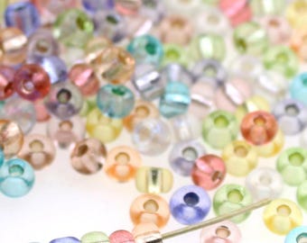 Tamaño 5/0 - 6/0 Mezcla de cuentas de vidrio Rocailles Preciosa - Arcoíris pastel transparente - Rosa, melocotón, verde, amarillo, azul, turquesa, morado, 4 mm - Bolsa de 20 g