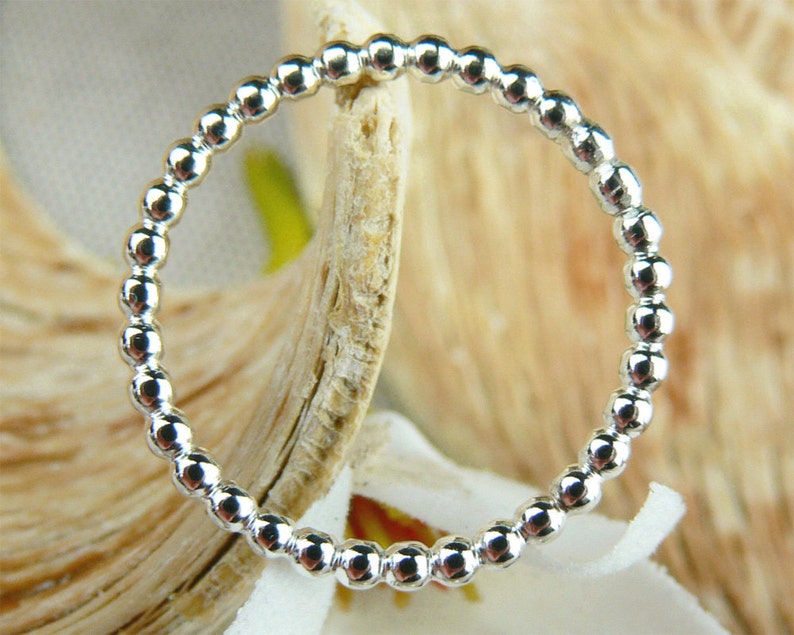 Puede incluir: Un anillo de plata con cuentas de dise&ntilde;o sencillo. El anillo est&aacute; hecho de peque&ntilde;as cuentas redondas que est&aacute;n espaciadas uniformemente.