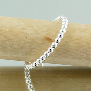 Puede incluir: Un brazalete de plata con cuentas redondas y lisas. Las cuentas est&aacute;n espaciadas uniformemente.