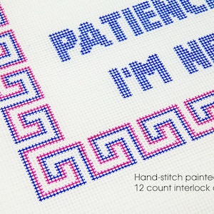 May include: Hand-stitched cross-stitch design on 12 count interlock canvas. The design features a blue and pink Greek key border and the text "Patience I'm New".