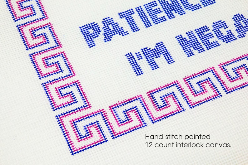 May include: Hand-stitched cross-stitch design on 12 count interlock canvas. The design features a blue and pink Greek key border and the text "Patience I'm New".
