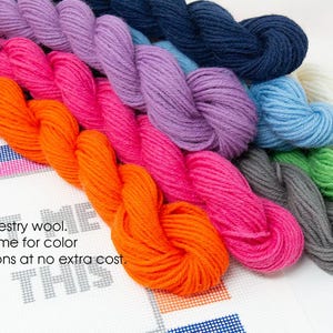 May include: A collection of 10 skeins of tapestry wool yarn in various colors, including orange, pink, purple, blue, gray, and green. The yarn is arranged in a row, with the ends of each skein overlapping the next. The yarn is 100% tapestry wool and is available in a variety of colors. Contact the seller for color substitutions at no extra cost.