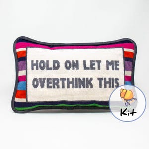 May include: A needlepoint pillow kit featuring a colorful striped border and the text "HOLD ON LET ME OVERTHINK THIS".
