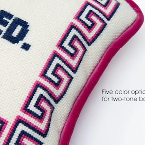 May include: White pillow with a blue and pink Greek key border and a pink leather trim. The pillow is embroidered with the text "TRUSTED." Five color options for two-tone border.