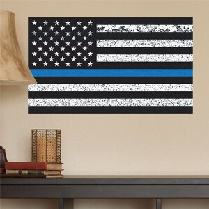 May include: A distressed American flag design with a blue line, white stars, and white and black stripes. The flag is rectangular and has a textured appearance, suitable for wall decor.