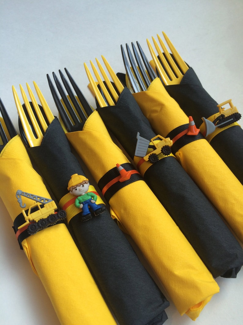 May include: Yellow and black construction themed party favor place card holders with toy construction vehicles and a construction worker figurine.