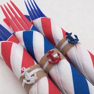 May include: Three red, white, and blue striped paper napkins with forks wrapped inside. Each napkin is tied with twine and a small anchor charm.