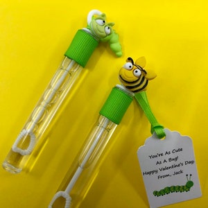 May include: Two green and yellow bubble wands with a bee and a caterpillar on top. The bee wand has a tag that says "You're As Cute As A Bug! Happy Valentine's Day. From, Jack."