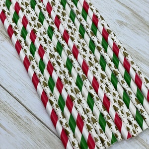 May include: A bundle of red and green striped paper straws with a white background and a gold Christmas tree pattern.