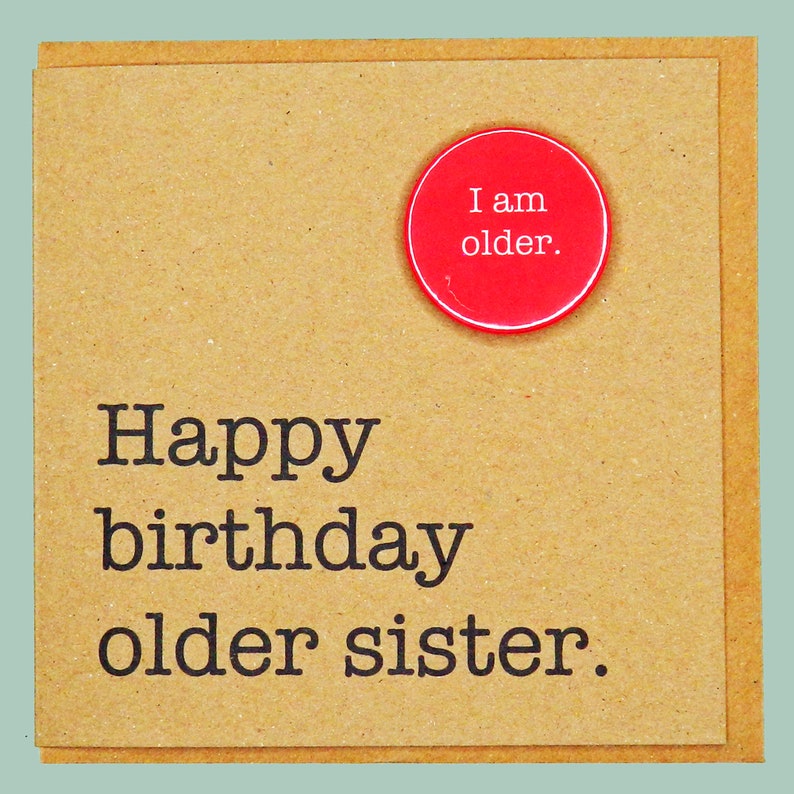 May include: A brown card with the text "Happy birthday older sister." A red button with the text "I am older." is attached to the card.