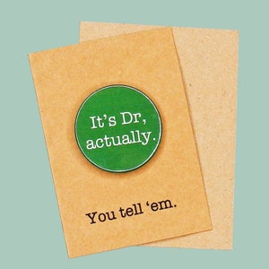 May include: A brown card with a green button that says "It's Dr, actually." The card also says "You tell 'em."