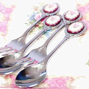 Pu&ograve; includere: Tre cucchiai d'argento con manici decorati e motivi floreali sulla parte superiore. I cucchiai hanno una forchetta all'estremit&agrave; del manico.