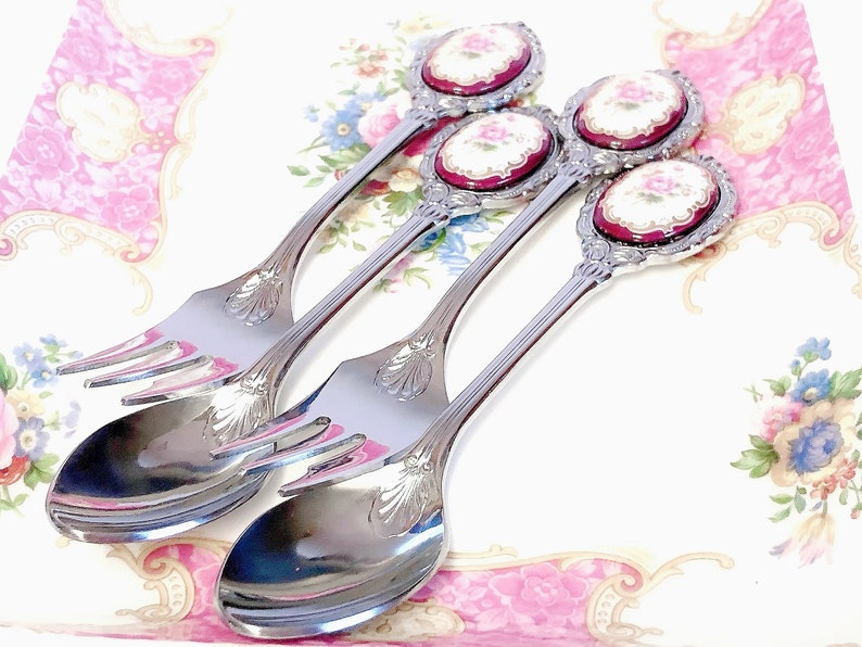 Pu&ograve; includere: Tre cucchiai d'argento con manici decorati e motivi floreali sulla parte superiore. I cucchiai hanno una forchetta all'estremit&agrave; del manico.