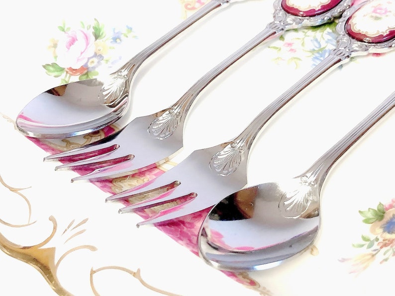 Pu&ograve; includere: Tre cucchiai d'argento con manici decorati e un motivo floreale. I cucchiai sono su uno sfondo bianco con un motivo floreale.