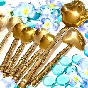 Puede incluir: Un juego de cucharas y cucharones de bamb&uacute; con mangos dorados. Las cucharas tienen una forma de cuenco redondeada, mientras que los cucharones tienen un cuenco m&aacute;s ancho y poco profundo. Los mangos son de bamb&uacute; y tienen un color marr&oacute;n natural.