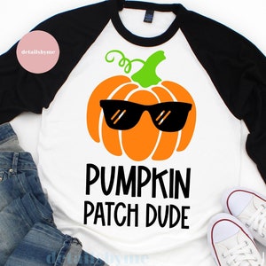 May include: A white and black baseball tee shirt with a pumpkin wearing sunglasses and the text "Pumpkin Patch Dude".