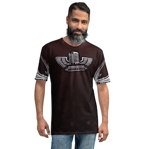 May include: A dark brown t-shirt with a white graphic of a microphone with wings and a harmonica. The graphic is centered on the shirt.