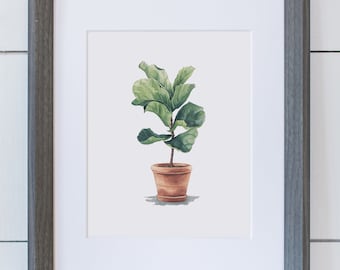 May include: A watercolor painting of a potted fiddle leaf fig plant with green leaves in a brown pot. The painting is framed in a gray frame.