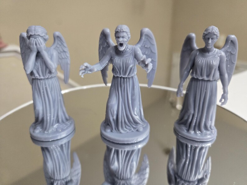 May include: A white ceramic mug with a black handle and the text "But First, Coffee" in a bold, black font. The mug is set against a blurred background, suggesting a cosy setting.