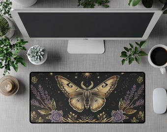 Op de afbeelding: Zwarte rechthoekige bureaumat met een illustratie van een mot met bruine en beige vleugels. De mat heeft een bloemen- en hemels ontwerp met paarse en gouden accenten. Een computermonitor, muis en koffiekopje zijn ook zichtbaar.