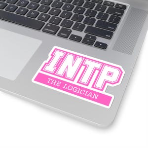 May include: A pink and white sticker with the text "INTP THE LOGICIAN" on a laptop. The sticker has a rectangular shape with a pink background and white text. The laptop is silver.