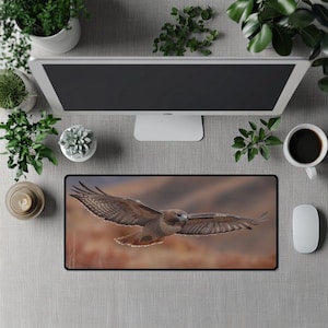 May include: A rectangular mouse pad featuring a detailed image of a hawk in flight. The hawk has brown and white feathers, with its wings spread wide. The background is a blurred landscape of brown and orange hues.