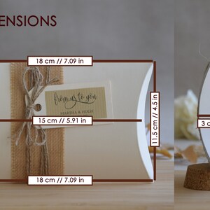 May include: White pillow box with a burlap ribbon and a gift tag that says "from us to you Martha & Hugh". The box measures 18 inches by 11.5 inches by 3 inches.