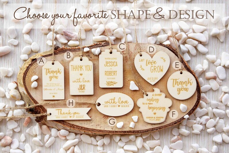 K&ouml;nnte beinhalten: Sortiment aus Holz-Hochzeitsgeschenkanh&auml;ngern in verschiedenen Formen und Designs. Die Anh&auml;nger zeigen den Text "Danke", "Mit Liebe", "Lass die Liebe wachsen", "Ein s&uuml;&szlig;er Abschluss f&uuml;r einen neuen Anfang" und "Mit Liebe".