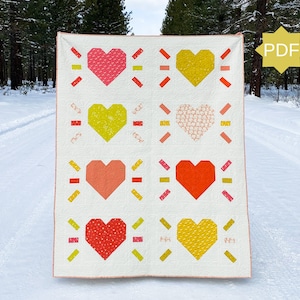 May include: A handmade quilt with a repeating heart pattern in pink, yellow, orange, and red. The hearts are set against a white background. The quilt has a PDF icon in the corner.