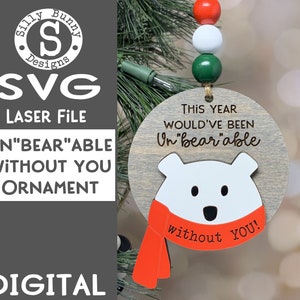May include: A wooden Christmas bauble featuring a white polar bear wearing a red scarf. The bauble reads "This year would've been Un"bear"able without you!"