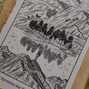 Puede incluir: Grabado en madera en blanco y negro de un paisaje de monta&ntilde;a con un lago y &aacute;rboles. El texto "Die Sprache der" es visible en la parte inferior de la impresi&oacute;n.