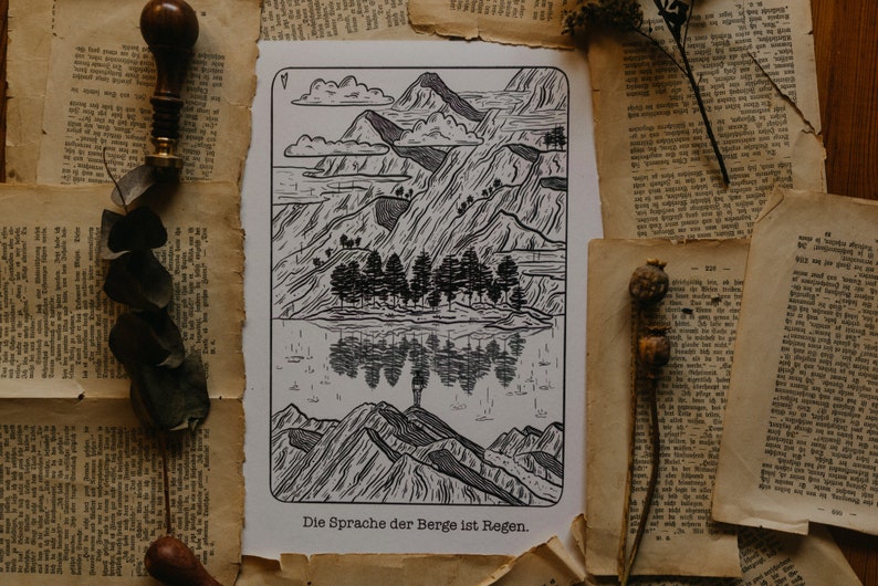 Puede incluir: Una impresi&oacute;n en madera en blanco y negro de una cordillera con un reflejo en un lago. El texto "Die Sprache der Berge ist Regen." est&aacute; en la parte inferior de la impresi&oacute;n.