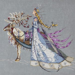 May include: Cross-stitch design of a woman in a blue gown with a long braid, standing next to a reindeer. The reindeer has decorative antlers and a purple saddle. The woman is wearing a crown and has a flowing cape.