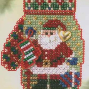 May include: A beaded Christmas ornament in the shape of a mitten, featuring Santa Claus. The ornament is primarily red, green, and white, with a gold heart and a stocking. The mitten is decorated with a festive pattern.
