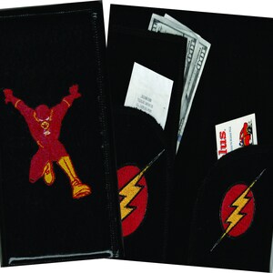 May include: Black leather wallet with a red and yellow embroidered image of The Flash. The wallet has a separate pocket with a red and yellow embroidered Flash logo.