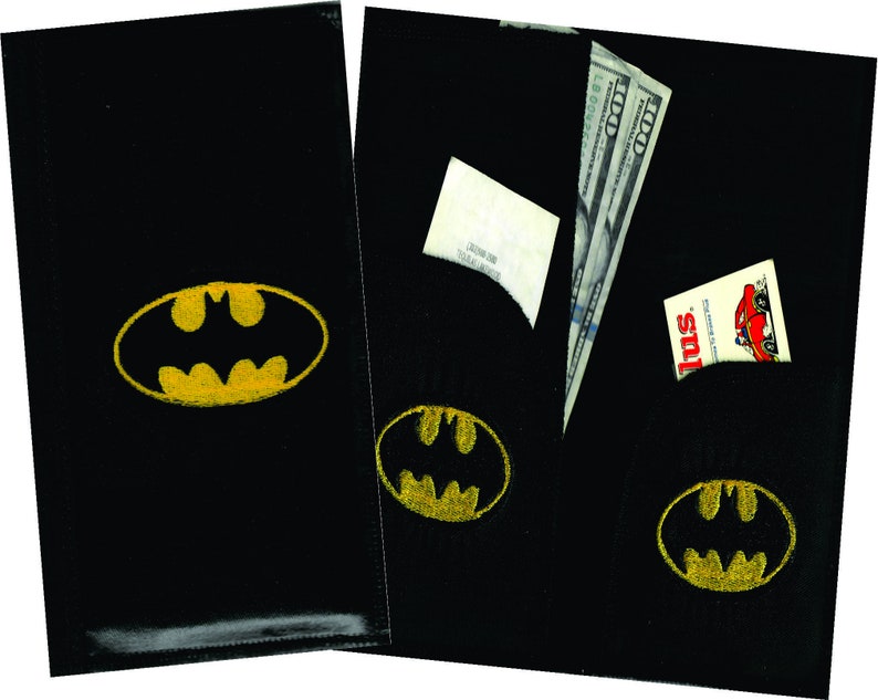 May include: Two black leather wallets with a yellow Batman logo. The wallet on the right has a pocket with a dollar bill and a small card sticking out.