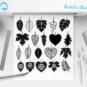 Puede incluir: Una hoja de dise&ntilde;os de hojas en blanco y negro para manualidades. Los dise&ntilde;os incluyen una variedad de formas de hojas, incluyendo hojas de arce, roble y palma. Los dise&ntilde;os est&aacute;n dispuestos en un patr&oacute;n de cuadr&iacute;cula sobre un fondo blanco.