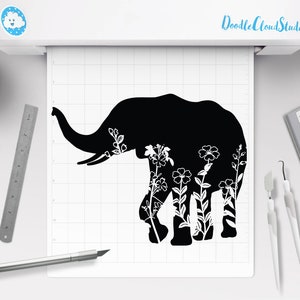 Puede incluir: Silueta negra de un elefante con diseños florales blancos dentro del contorno. El elefante está mirando hacia el lado izquierdo de la imagen.