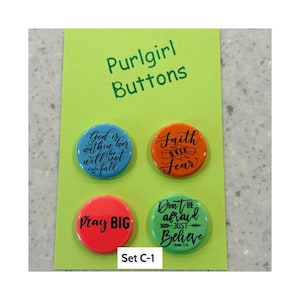 May include: A set of four round buttons on a lime green card labeled Purlgirl Buttons and Set C-1. The buttons are blue, orange, red, and green, each featuring black text with inspirational phrases including God is within her, Faith over fear, Pray BIG, and Don't be afraid just believe.