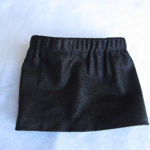 May include: A black faux leather skirt with a textured surface and an elastic waistband.