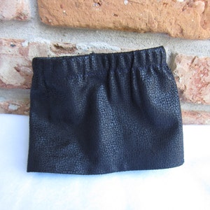 May include: A black faux leather skirt with a gathered elastic waistband.