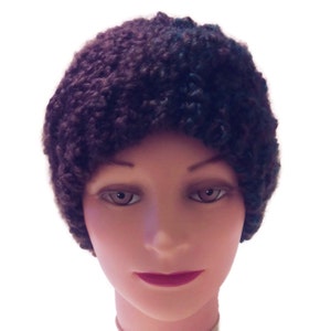 May include: A brown and black knitted beanie hat with a fluffy texture.