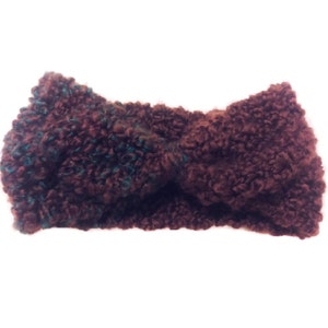 May include: A brown and teal fuzzy headband with a twisted knot design.
