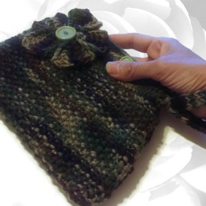 May include: A camouflage crocheted bag with a green flower embellishment and a button. The bag has a long strap that can be worn on the wrist.